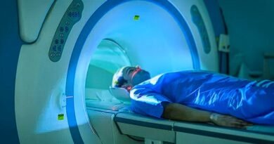 A man wearing blue robes moving into MRI machine